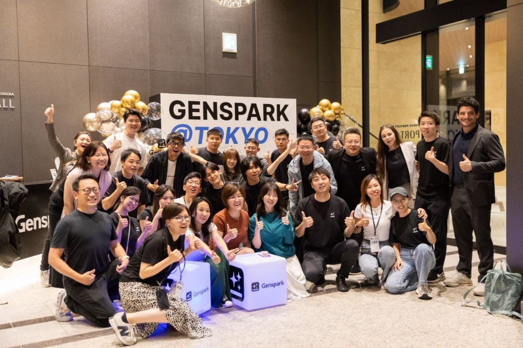 The Genspark Tokyo team gathered around a GENSPARK @ TOKYO sign with gold balloons